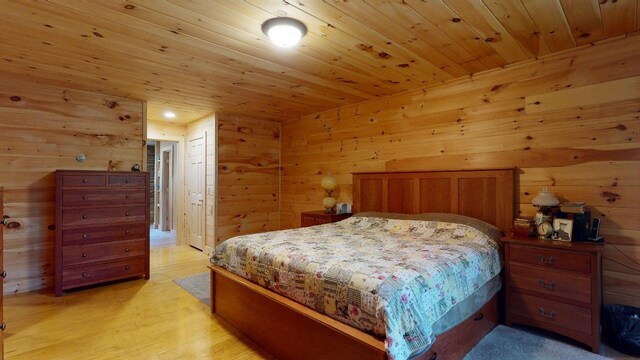 bedroom featuring wooden walls, wood ceiling, and light wood-type flooring
