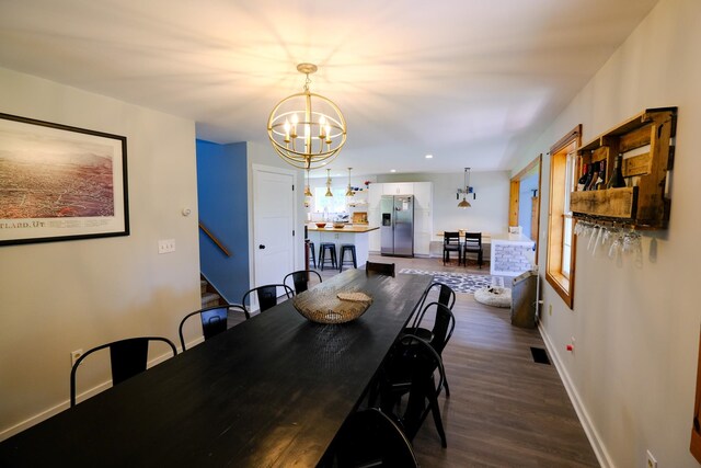 dining space featuring an inviting chandelier, visible vents, dark wood-type flooring, baseboards, and stairs
