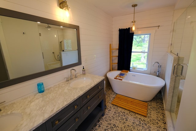 bathroom with a freestanding bath, a sink, double vanity, and a stall shower