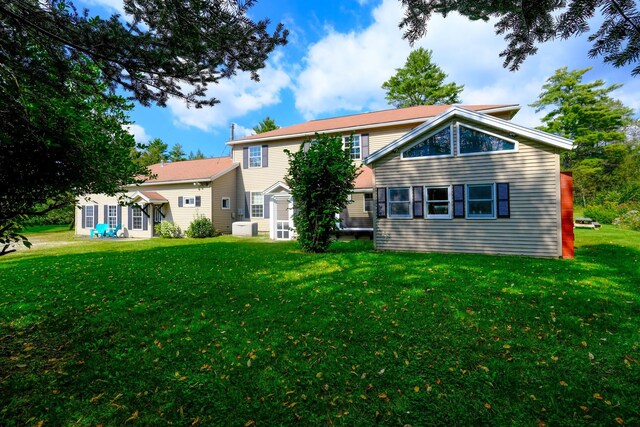 rear view of property featuring a yard