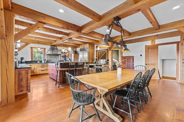 dining area with bar, light wood-type flooring, and beamed ceiling