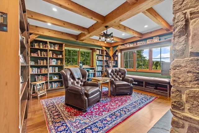 living area with a notable chandelier, coffered ceiling, beamed ceiling, and wood-type flooring