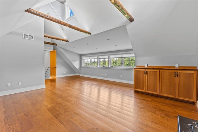 additional living space featuring light wood-type flooring and vaulted ceiling