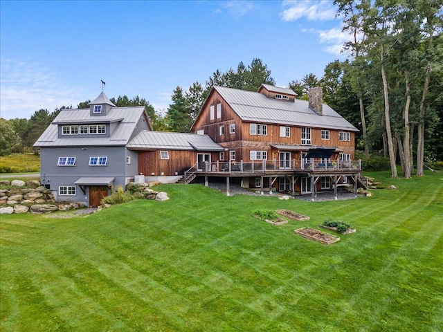 back of property with a deck and a lawn