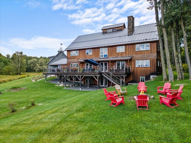 back of property featuring a wooden deck and a yard