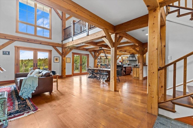 living room with french doors, beamed ceiling, and hardwood / wood-style floors