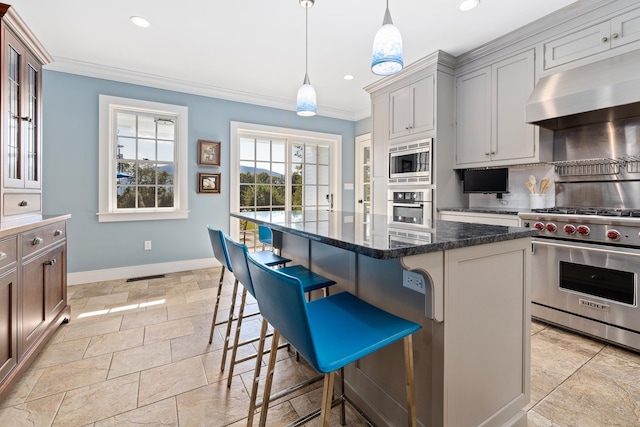 kitchen with a kitchen island, ventilation hood, a kitchen bar, hanging light fixtures, and stainless steel appliances