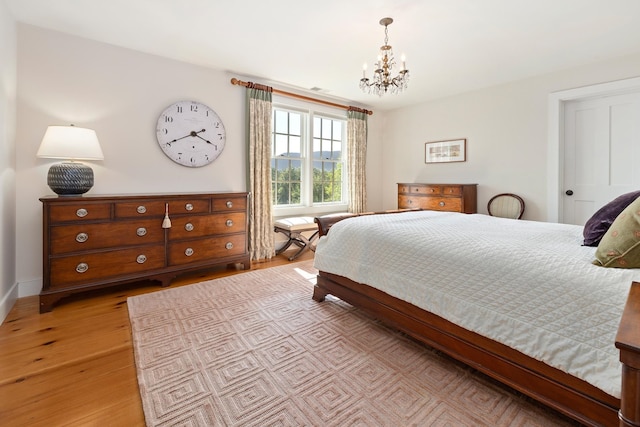 bedroom featuring a chandelier and light hardwood / wood-style floors