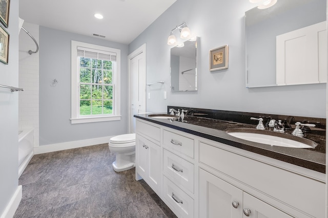 full bathroom featuring vanity, tiled shower / bath, and toilet