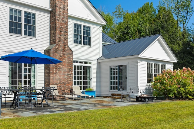 back of house with a lawn and a patio area