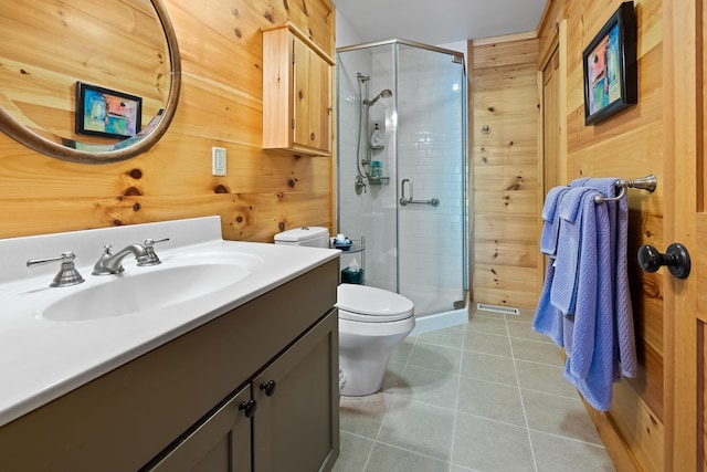 bathroom with tile patterned flooring, wooden walls, toilet, and walk in shower