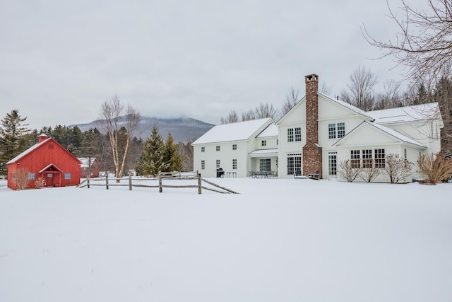 snow covered rear of property with a mountain view