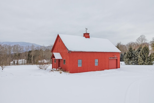 snow covered structure featuring a mountain view