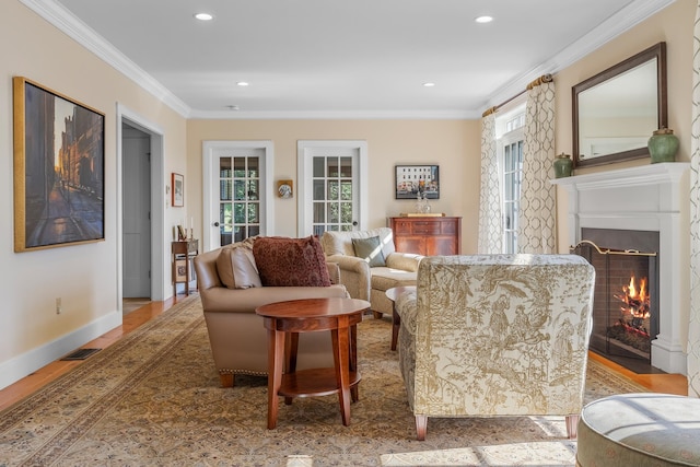 living room with ornamental molding, plenty of natural light, and light hardwood / wood-style flooring