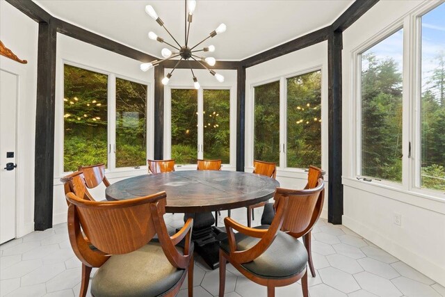 sunroom featuring plenty of natural light and a notable chandelier