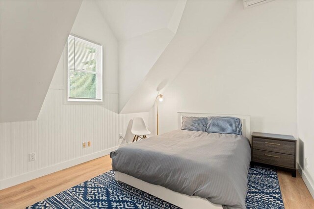 bedroom with lofted ceiling and light wood-type flooring