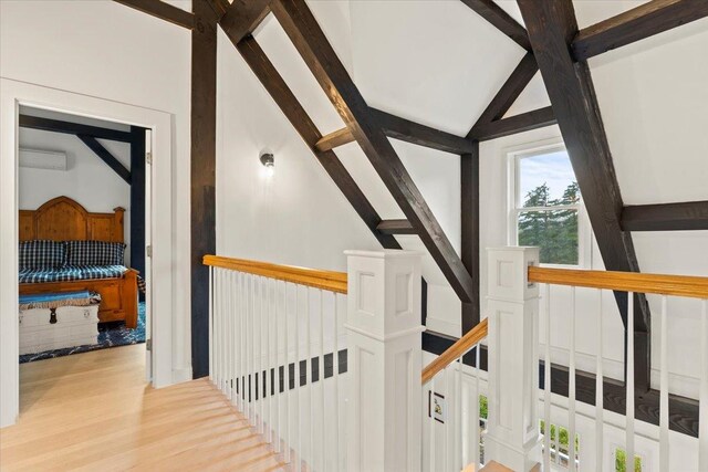 hall with vaulted ceiling with beams and light wood-type flooring