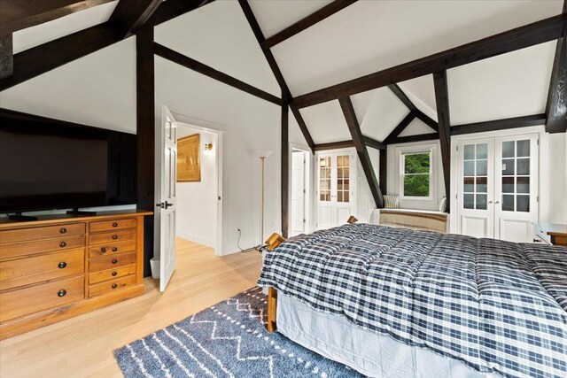 bedroom featuring light hardwood / wood-style flooring, lofted ceiling with beams, and french doors