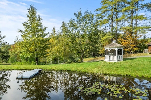 dock area with a water view, a gazebo, and a yard