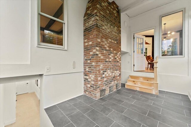 interior space featuring brick wall and a chandelier