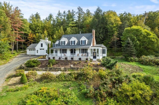 cape cod home with covered porch and a garage