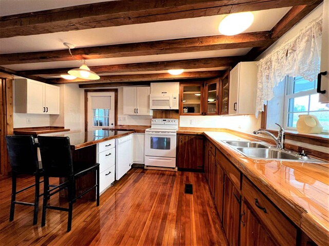 kitchen featuring white appliances, white cabinets, dark hardwood / wood-style flooring, and beamed ceiling