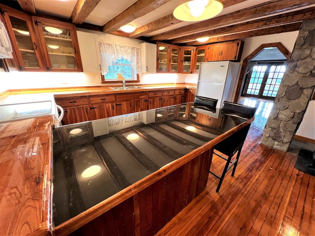 kitchen featuring white refrigerator, sink, dark hardwood / wood-style floors, and beamed ceiling