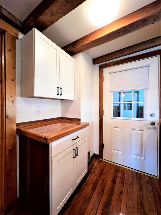 kitchen featuring wood counters, dark hardwood / wood-style floors, white cabinetry, and beamed ceiling