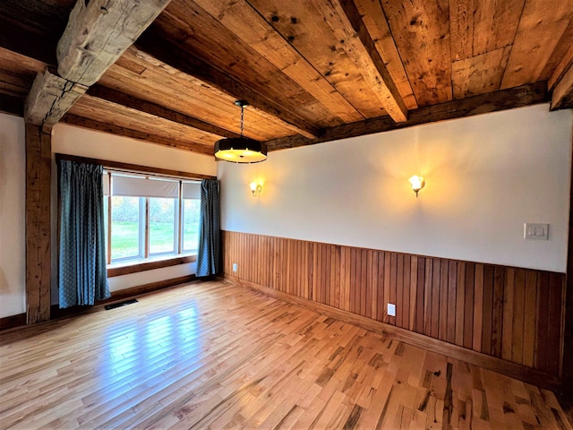 empty room with light hardwood / wood-style flooring, beamed ceiling, and wooden ceiling