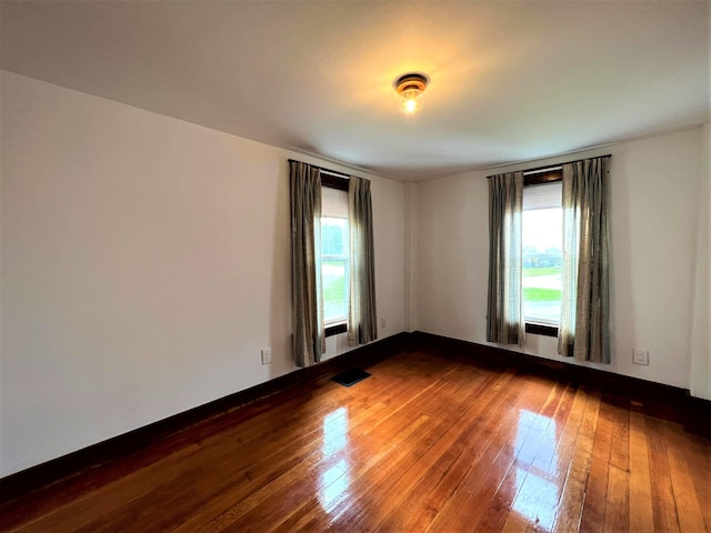 unfurnished room with dark wood-type flooring