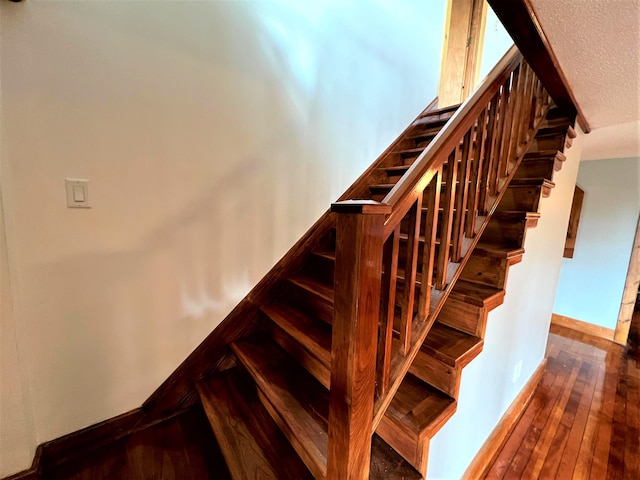 staircase with dark hardwood / wood-style floors