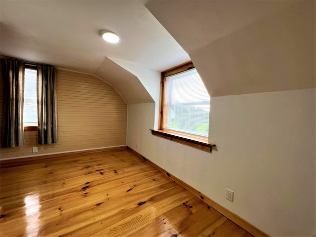 bonus room with vaulted ceiling and light wood-type flooring