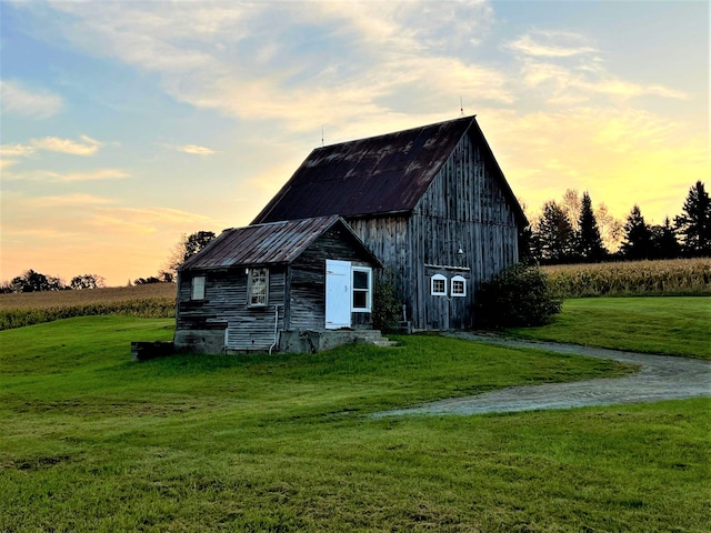 outdoor structure at dusk featuring a lawn