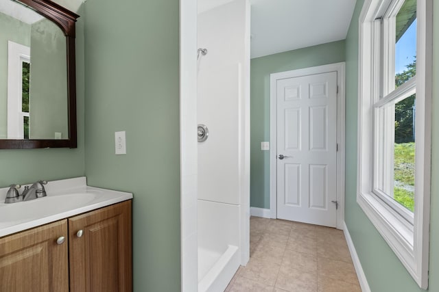 bathroom featuring tile flooring, walk in shower, and vanity