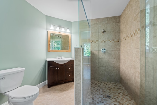 bathroom featuring toilet, large vanity, tile floors, and tiled shower