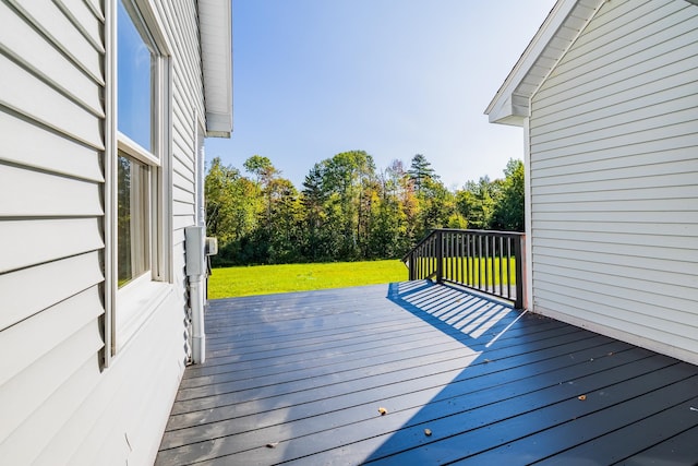 wooden deck featuring a lawn