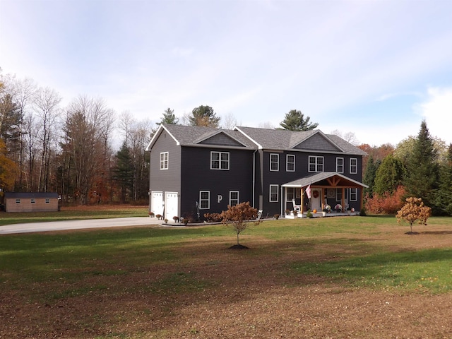 rear view of property featuring a garage and a lawn