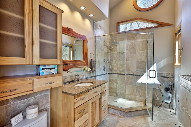 bathroom with walk in shower, lofted ceiling, tile walls, tile flooring, and vanity with extensive cabinet space