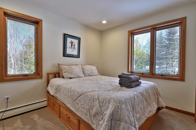 carpeted bedroom with multiple windows and baseboard heating