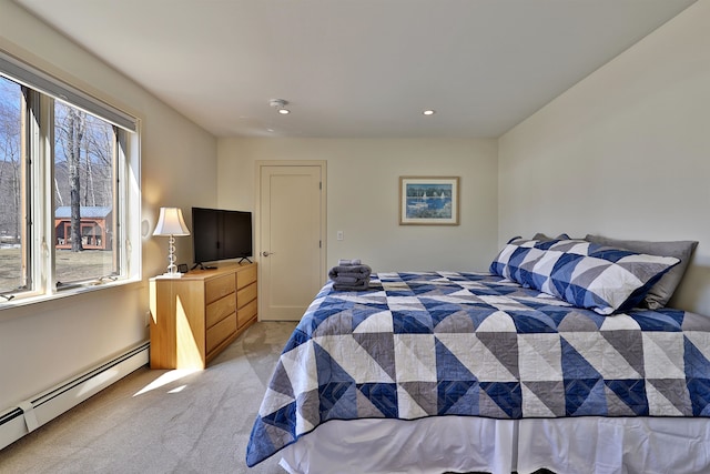 bedroom with light colored carpet, multiple windows, and baseboard heating