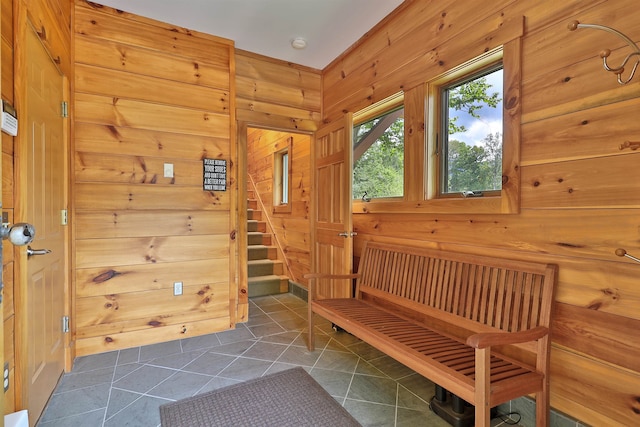 interior space with wooden walls and dark tile floors