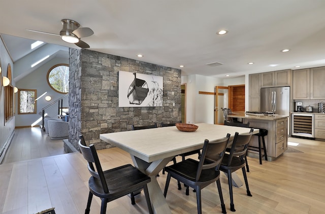 dining area with beverage cooler, vaulted ceiling, light hardwood / wood-style floors, and ceiling fan