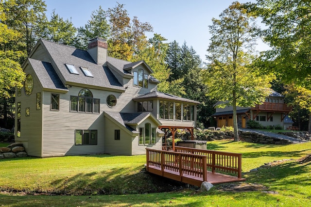 back of property featuring a wooden deck and a yard