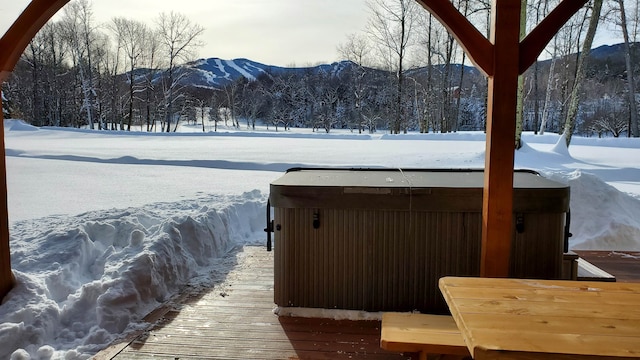 view of dock with a mountain view and a hot tub