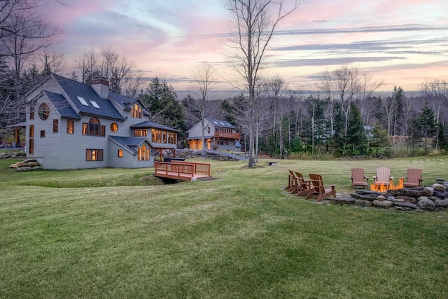 yard at dusk featuring a fire pit and a deck