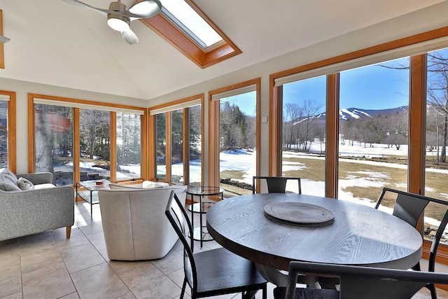 sunroom featuring a mountain view, lofted ceiling with skylight, and ceiling fan