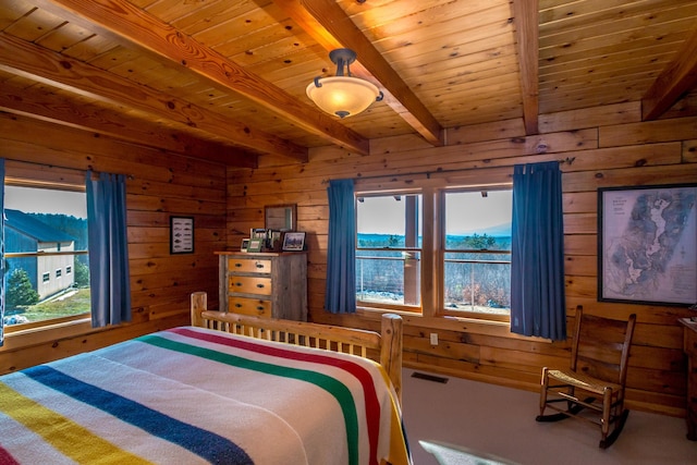 bedroom featuring wooden walls, beam ceiling, and multiple windows