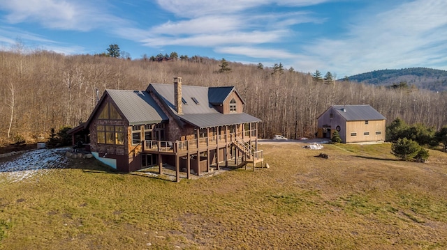 back of house featuring a lawn and a deck