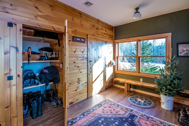 interior space featuring wood-type flooring and wood walls