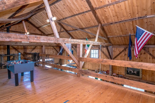 recreation room with wood ceiling, hardwood / wood-style flooring, lofted ceiling with beams, and wood walls